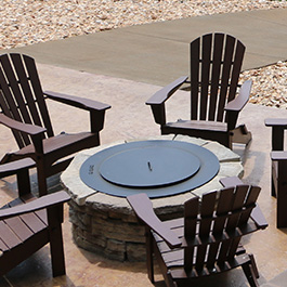 Propane firepit with chairs around it on a patio