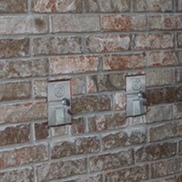 A brick wall with two propane access points