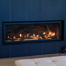 Linear propane fireplace in a living room wall with a black tile surround