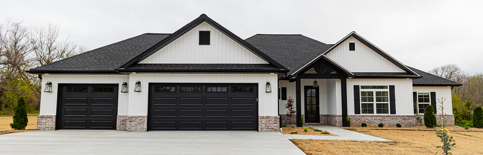 A white farmhouse with black trim, doors and accents