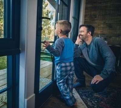 Man and child looking out window